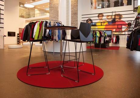 Rødt, rundt filtttæppe i showroom